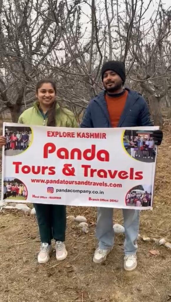 A beautiful couple who booked Kashmir honeymoon package with Panda Tours and Travels getting clicked with placard