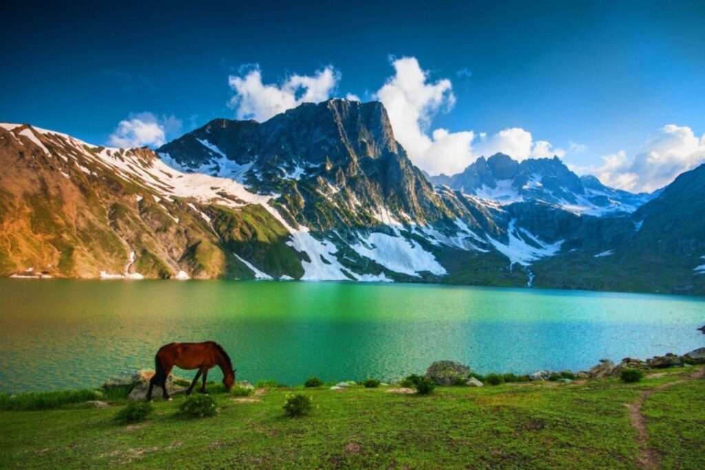 Green alpine landscape with lake and mountains on the Kashmir Great Lakes Trek
