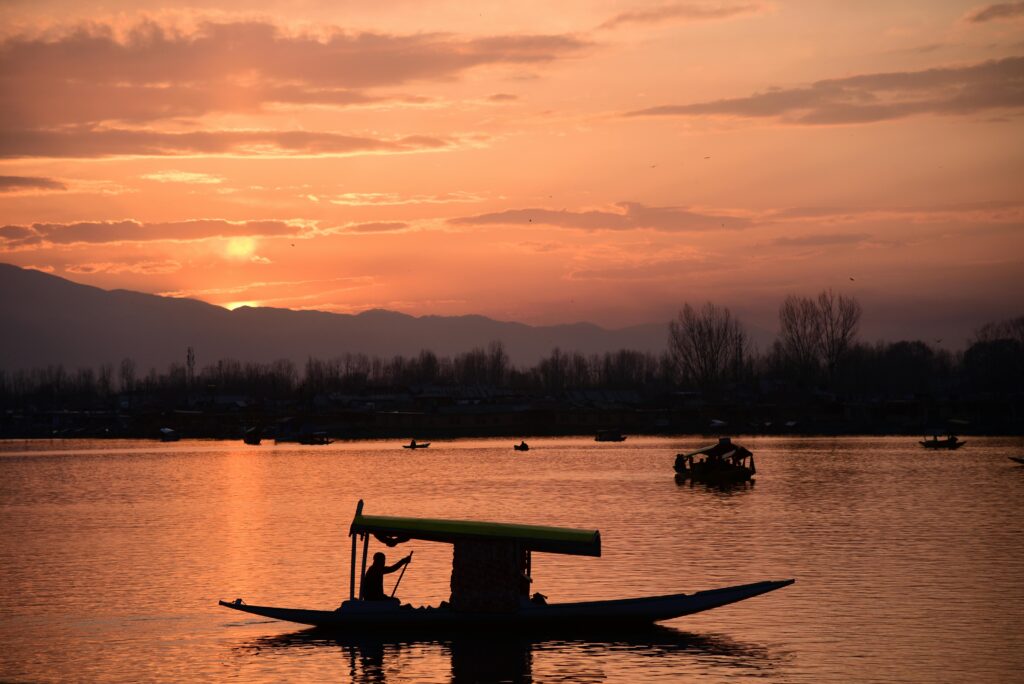 Dal Lake in Srinagar with shikaras and traditional houseboats surrounded by mountains | Panda Tours and Travels