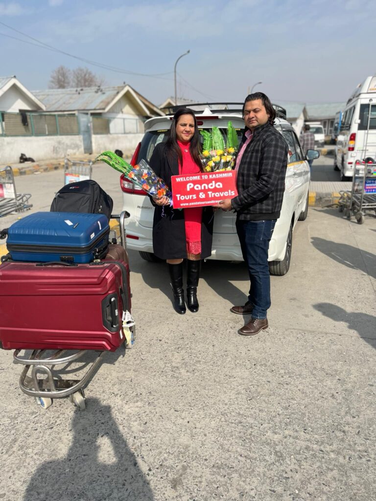 Satisfied guests holding Panda Tours and Travels board during Kashmir tour