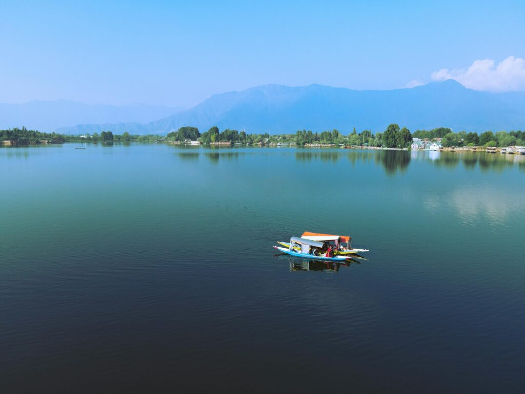 Nigeen Lake in Srinagar with calm waters, luxury houseboats, and mountain reflections in Kashmir | Panda Tours and Travels