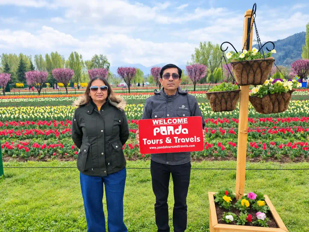 Tourists at tulip garden with board of panda tours and tarvels
