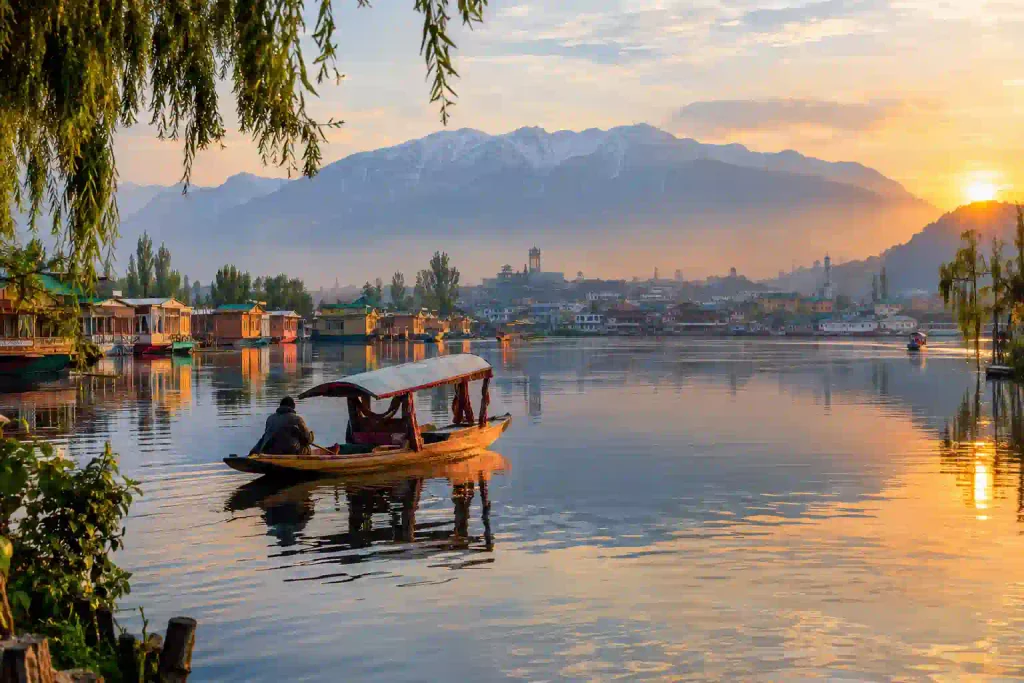 Best Places to Visit in Kashmir 2 Traditional wooden shikara gliding across the calm waters of Dal Lake in Srinagar during an early morning with reflections of houseboats and Himalayan mountains, Kashmir, India.