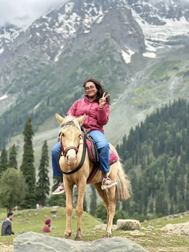 Tourist enjoying a horse ride in Sonamarg, Kashmir with snow-capped mountains in the background