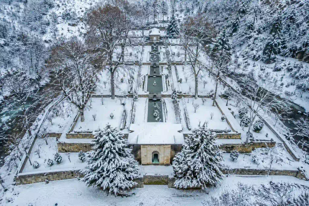 Achabal Garden, Kashmir: History, Location And Travel Guide 3 Aerial drone view of Achabal Garden covered in snow during winter in Kashmir