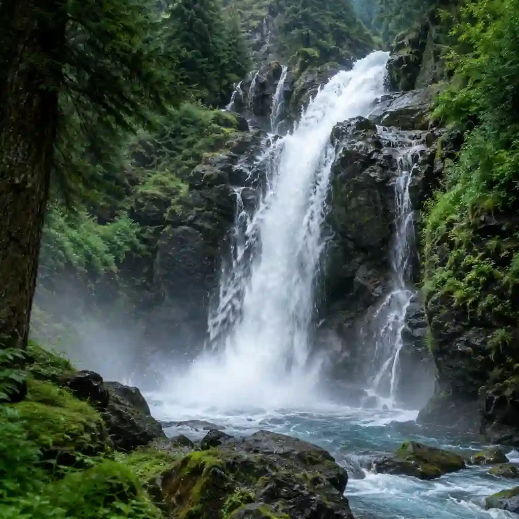 Best Places to Visit in Kashmir 9 Aharbal Waterfall in Kashmir cascading over dark moss-covered rocks through a dense green forest with mist rising from the pool.